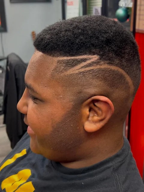 Fade with a freehand hair design and crisp lineup