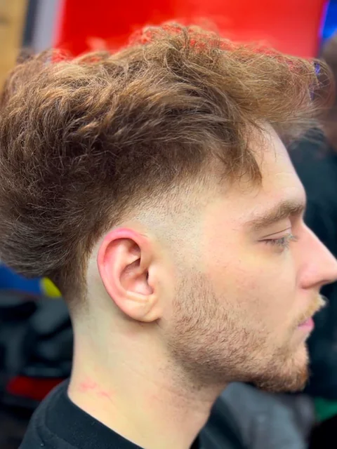 Low taper fade with a textured curly top